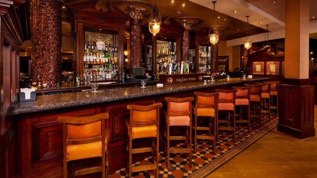A row of bar chairs at a long granite-topped bar