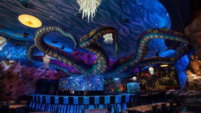Un pulpo gigante extiende sus tentáculos sobre un bar con un tema submarino