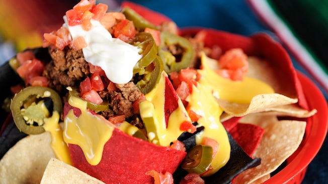Nachos cubiertos con carne picada, queso, rodajas de jalapeño, tomates en cubitos y Sour Cream