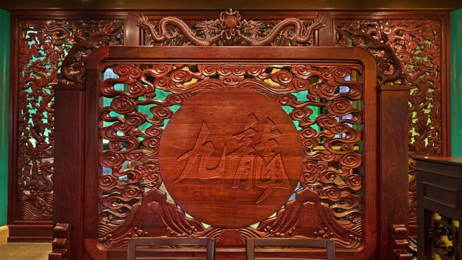 Wood carving with Chinese characters, dragons, 2 mountains and curling smoke