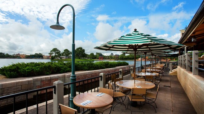 Patio with umbrellaed tables and views of the World Showcase Lagoon