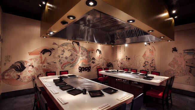 Two dining tables with built-in grills, a ventilation hood and Japanese wall murals 