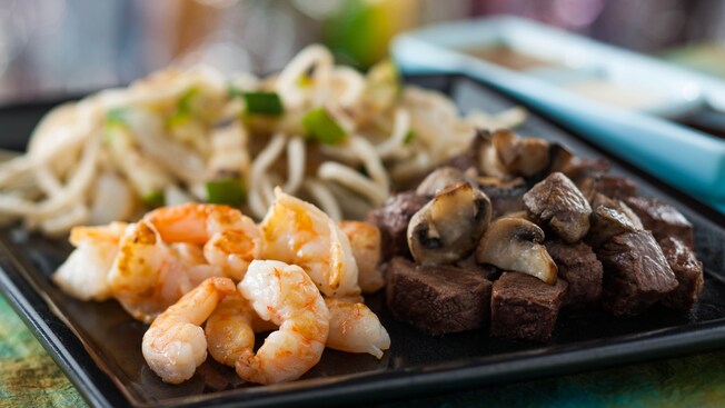 Grilled shrimp, steak with mushrooms, and vegetables and noodles