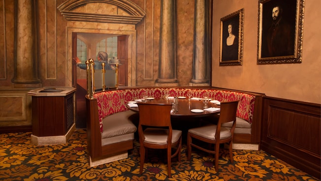 Asientos curvos para banquetes en un rincón del área de comidas principal junto a un mural