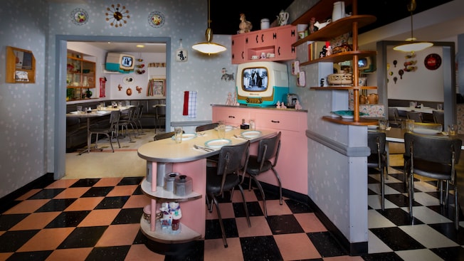 A pink-and-black kitchenette area with a 