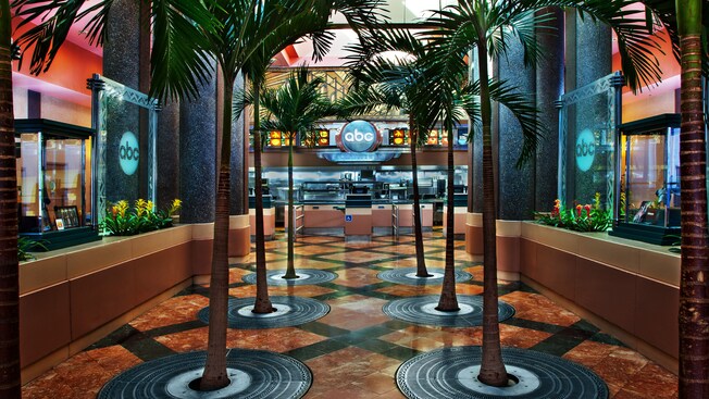 Dos hileras de palmeras adornan la entrada interior de ABC Commissary en Disney's Hollywood Studios
