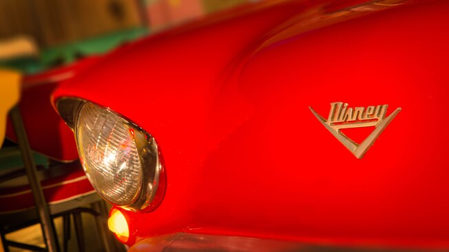 Close-up do farol e da chapa de identificação Disney em um carro vermelho