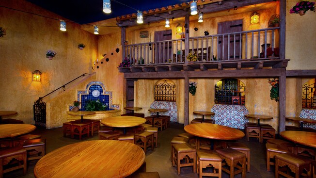 Dining area with Southwest-style tables and chairs, hanging lanterns and mock balcony