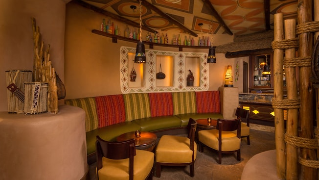 Low lounge tables and banquette along wall decorated with rustic vessels