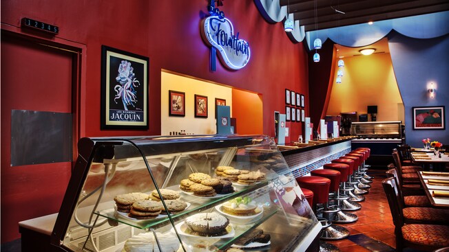 Glass display case with cookies and bake goods next to counter dining area