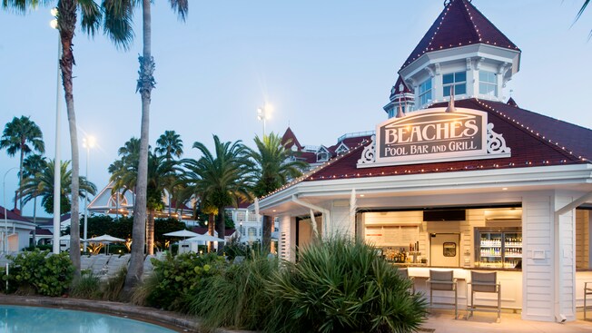 Outdoor lamps & festive lights illuminate the pool area as dusk sets in at Beaches Pool Bar & Grill