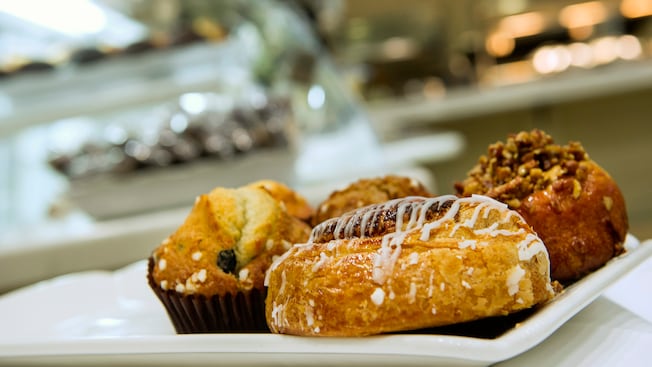Desayuno de pasteles recién horneados, que incluye panecillos daneses, muffins y rollos de canela