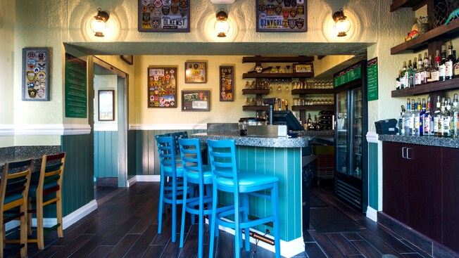 Stools line the Gurgling Suitcase bar as vanity license plates, badges & patches decorate the walls