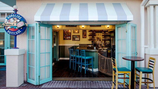 An exterior Gurgling Suitcase sign and seating area lead the way into the location’s bar and décor
