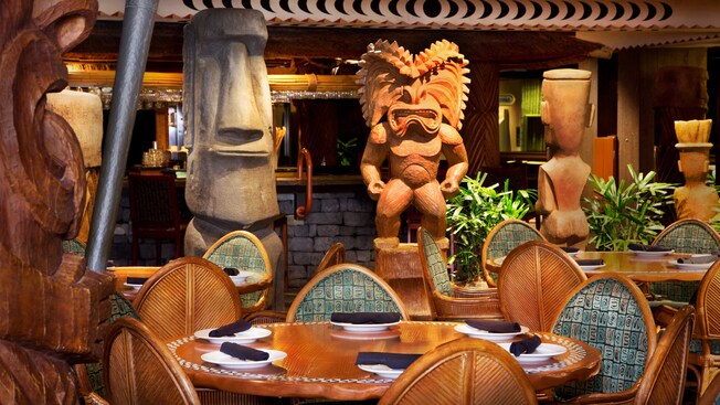 Round table in front of Hawaiian god Ku and an Easter Island-inspired moai statue