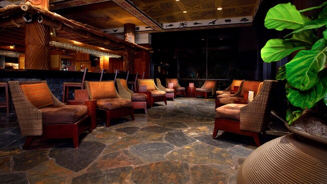 Sitting area with cushioned wicker chairs next to the bar