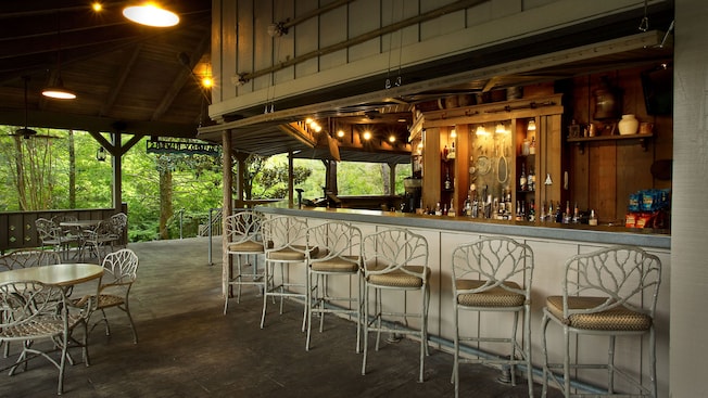 Row of wrought iron chair-stools at bar in covered area of patio