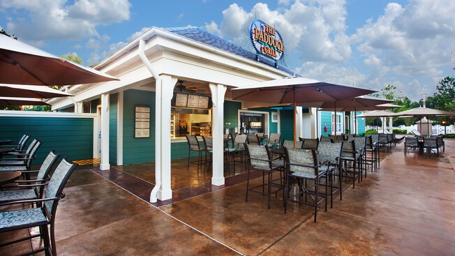 Exterior of The Paddock Grill, with umbrellaed patio tables 