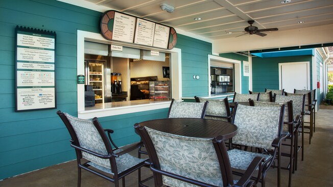 Row of patio tables beside Paddock Grill service windows, with menu boards 