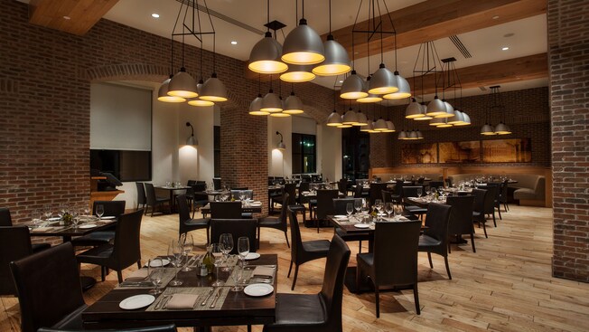 Alternate view of dining room, with dark modern furniture and overhead clusters of lamps