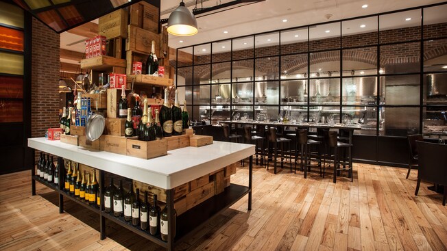 Boxes, cookie tins, and bottles of wine and Champagne stacked on a large island table