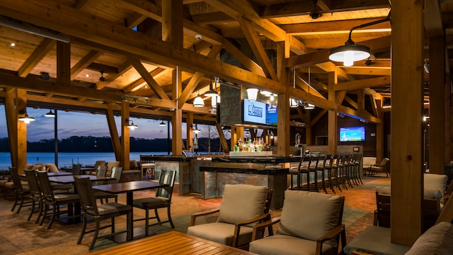 The illuminated open air interior of Geyser Point Bar & Grill with a spacious bar area and assorted chair and table setups