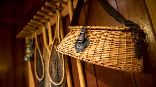 A small wicker basket hanging on a wall beside 4 fishing nets
