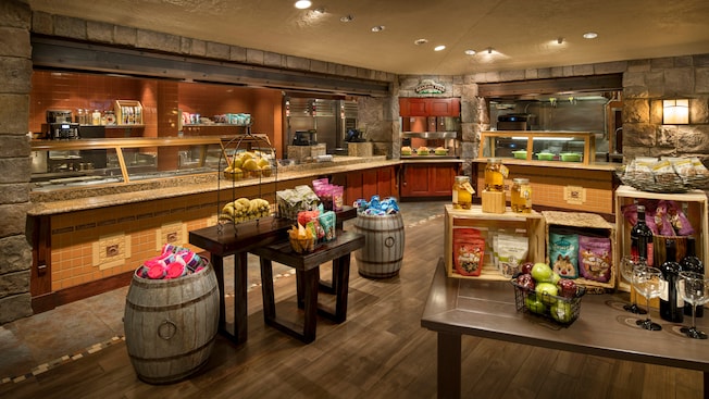 A cafeteria with several food stations and 2 tables filled with snacks