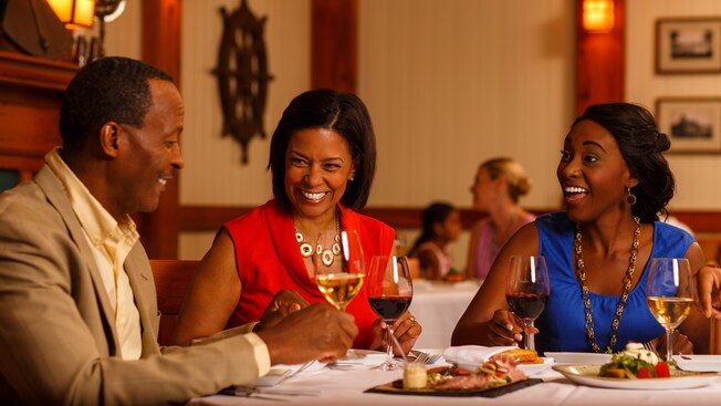 Three Guests enjoy wine and hors d'oeuvre at a dinner table at Yachtsman Steakhouse