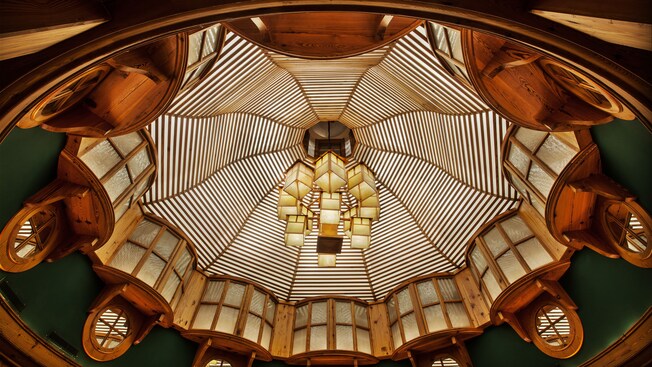 Vaulted ceiling with a linear design, box-like chandeliers and convex windows