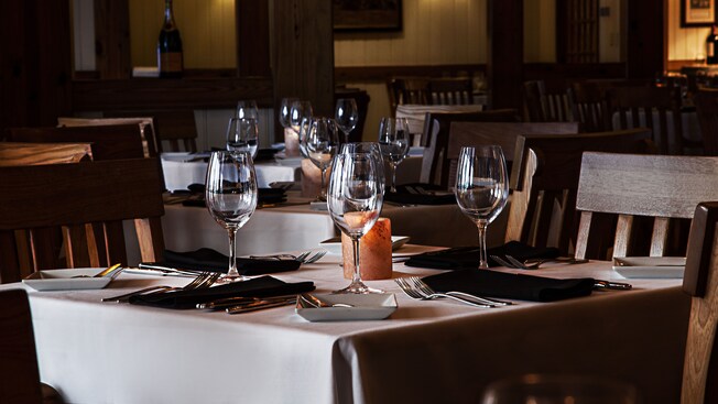 Three tables set for dinner, each with 4 wine glasses