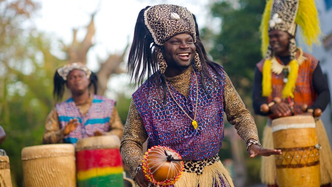 A dancer shakes to the beat of congas played by fellow members of Tam Tam Drummers of Harambe