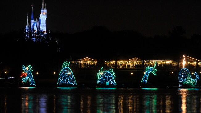 A sea serpent float in the Electrical Water Pageant and Cinderella Castle in the background