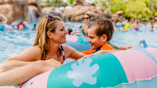 A mother plays with her son who's sitting in an inner tube in Melt-Away Bay