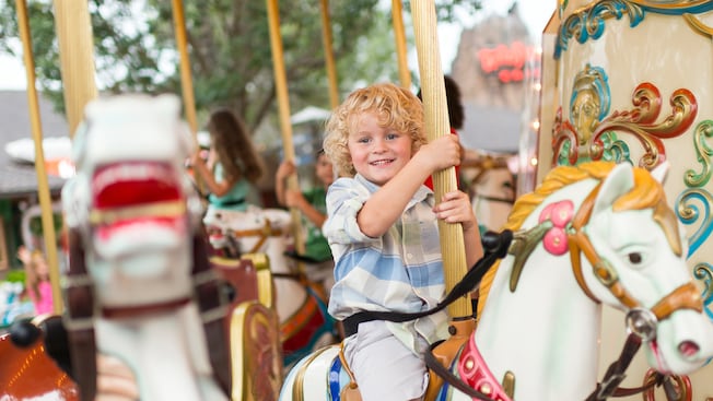 A young boy rides the Marketplace Carousel at Disney Springs