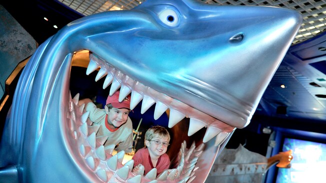 Two boys smile from inside the jaws of Bruce the Shark from Disney’s ‘Little Nemo’ at SeaBase in Epcot.