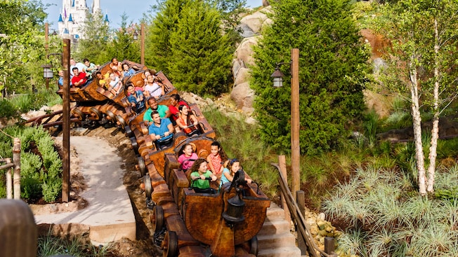 A group of people ride Seven Dwarfs Mine Train at Magic Kingdom Park
