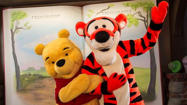 Winnie the Pooh y Tigger posando frente a un libro de cuentos en The Thotful Spot en Magic Kingdom Park