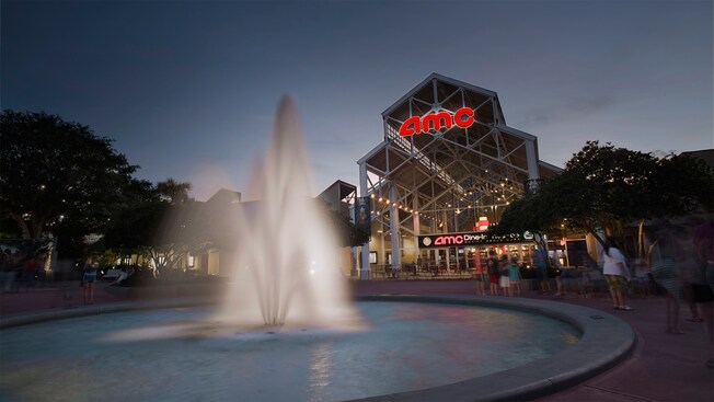 A decorative fountain in front of the AMC Disney Springs 24 theater at dusk