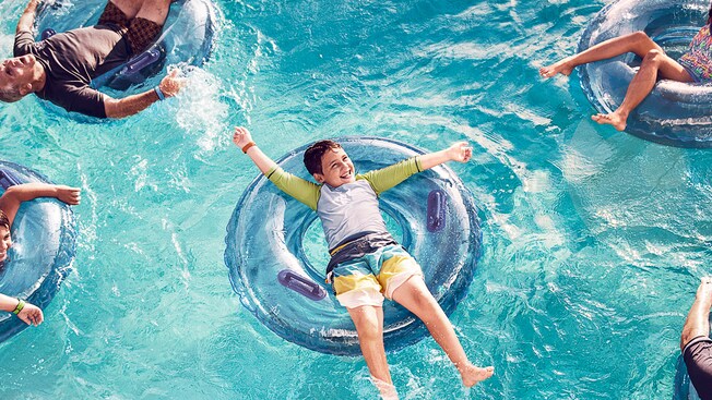 Un grupo de niños se relaja en sus flotadores individuales en una piscina