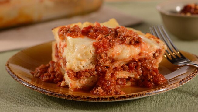 A serving of baked lasagna featuring ricotta cheese, meat, marinara and other Italian ingredients