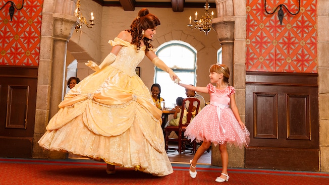 Princess Belle dances with a girl dressed as a princess