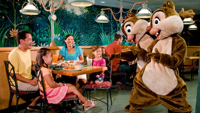 Mickey Mouse in farmer's garb greets Dad, Mom and daughter at Garden Grill