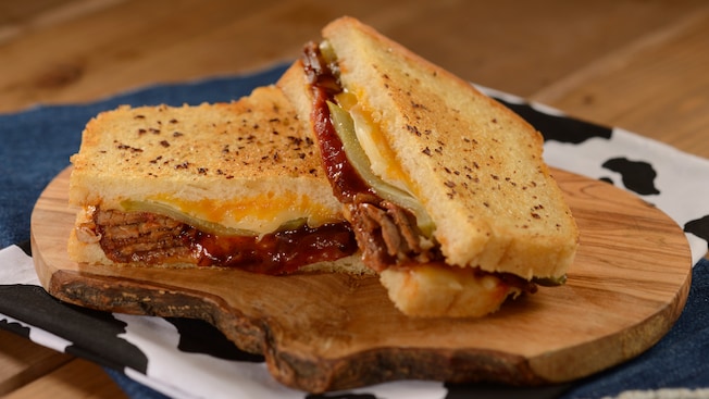 A barbecue brisket melt sandwich served atop a wooden cutting board at Woody’s Lunch Box