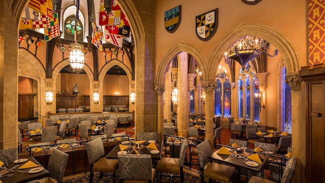 Cinderella’s Royal Table dining area features soaring stone archways and majestic stained-glass windows