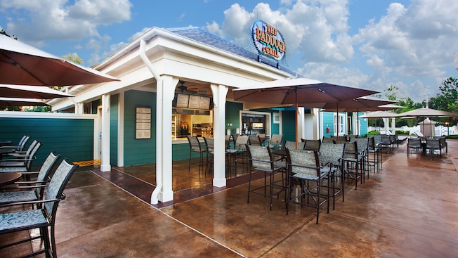 Exterior of The Paddock Grill, with umbrellaed patio tables