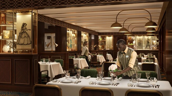 Un camarero arregla las flores en una mesa de un elegante restaurante al estilo de los años 20, decorado con muestras de la utilería y dibujos de varias películas de Disney