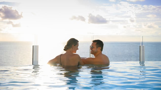 Two Guests relaxing and enjoying the view from an infinity pool on a Disney Cruise Line ship Two Guests relaxing and enjoying the view from an infinity pool on a Disney Cruise Line ship