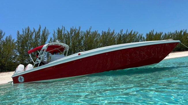 A boat floating in shallow water near the shoreline