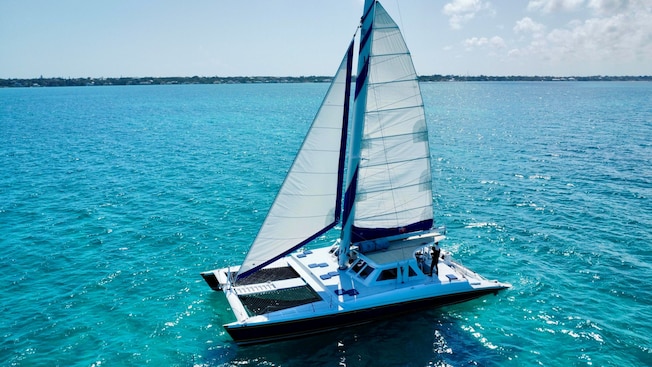 Un catamarán con vela en el mar Un catamarán con vela en el mar